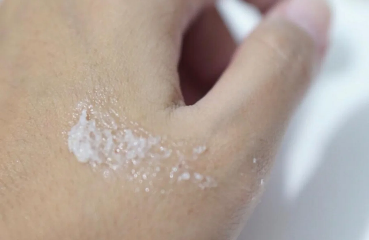 Butiran scrub halus Emina Sugar Rush Lip Scrub berwarna putih saat diaplikasikan di permukaan kulit tangan